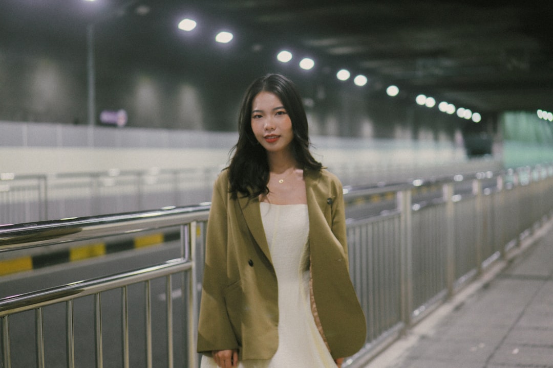 a-woman-in-a-white-dress-and-a-green-jacket-mvd5ld3eouu